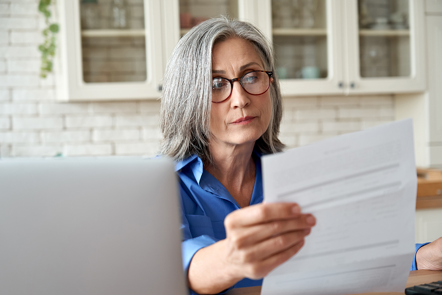 An elderly woman looking at her bills